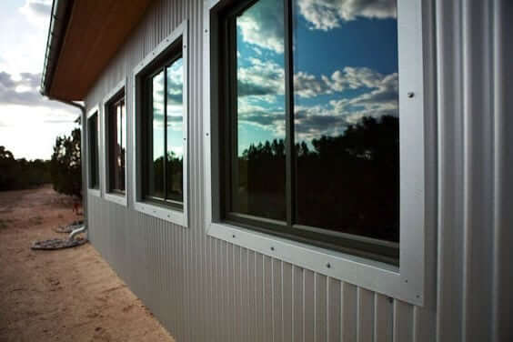 A metal building designed by a home designer, with windows and the sky in the background.