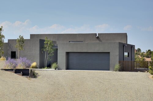 A modern home designed by an architect in Santa Fe, complete with a spacious driveway and garage.