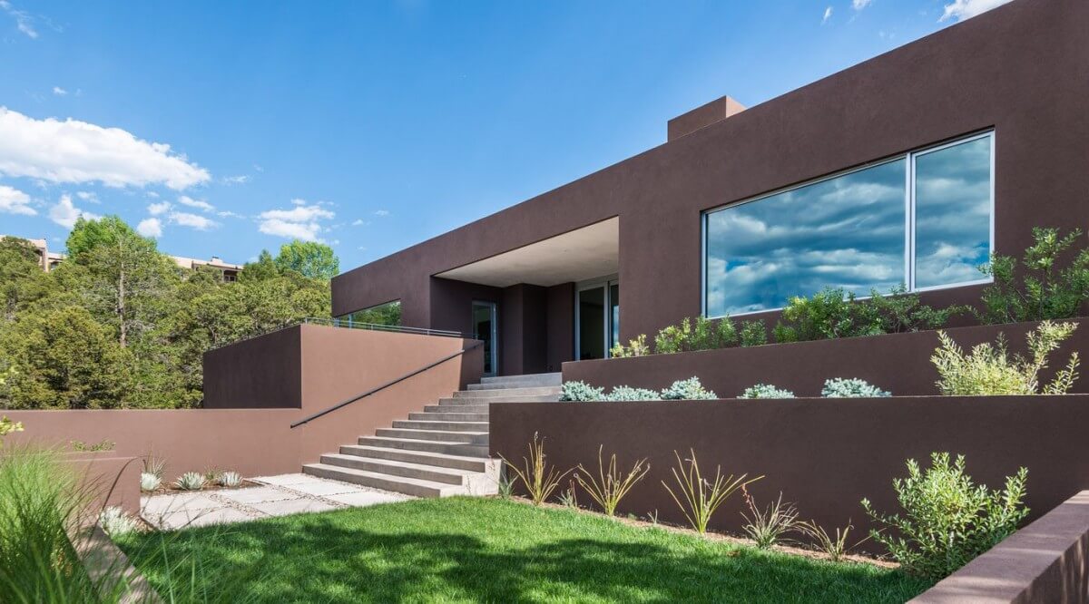 A modern home architecturally designed with a brown exterior and steps.