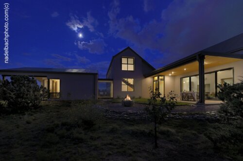 A Santa Fe home designer perfectly illuminates a modern home at night with a full moon.