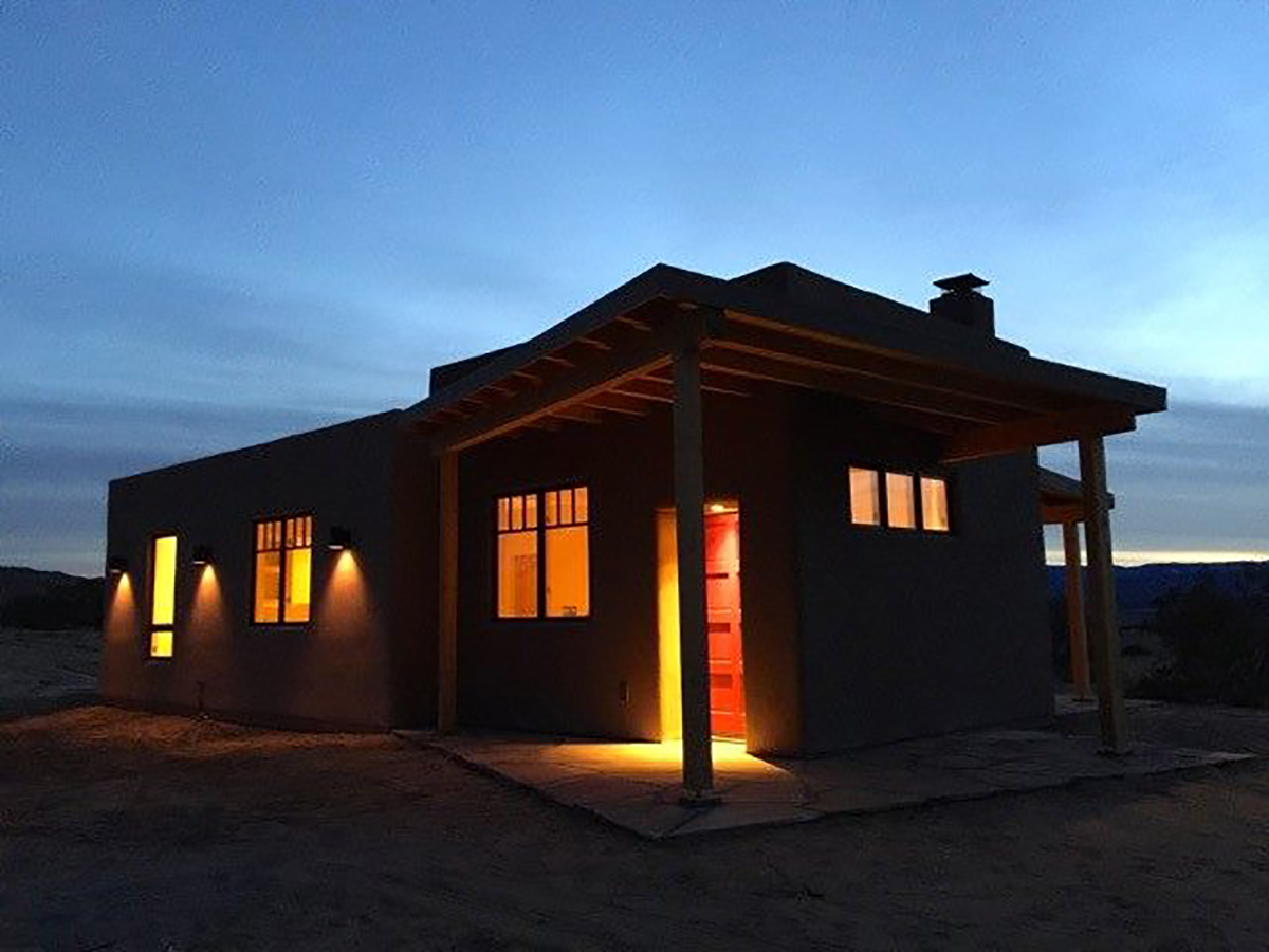 The Santa Fe home is lit up at night in the desert.