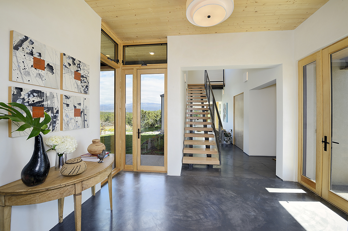 A contractor-designed hallway featuring an architect-inspired staircase and an elegant vase of flowers.