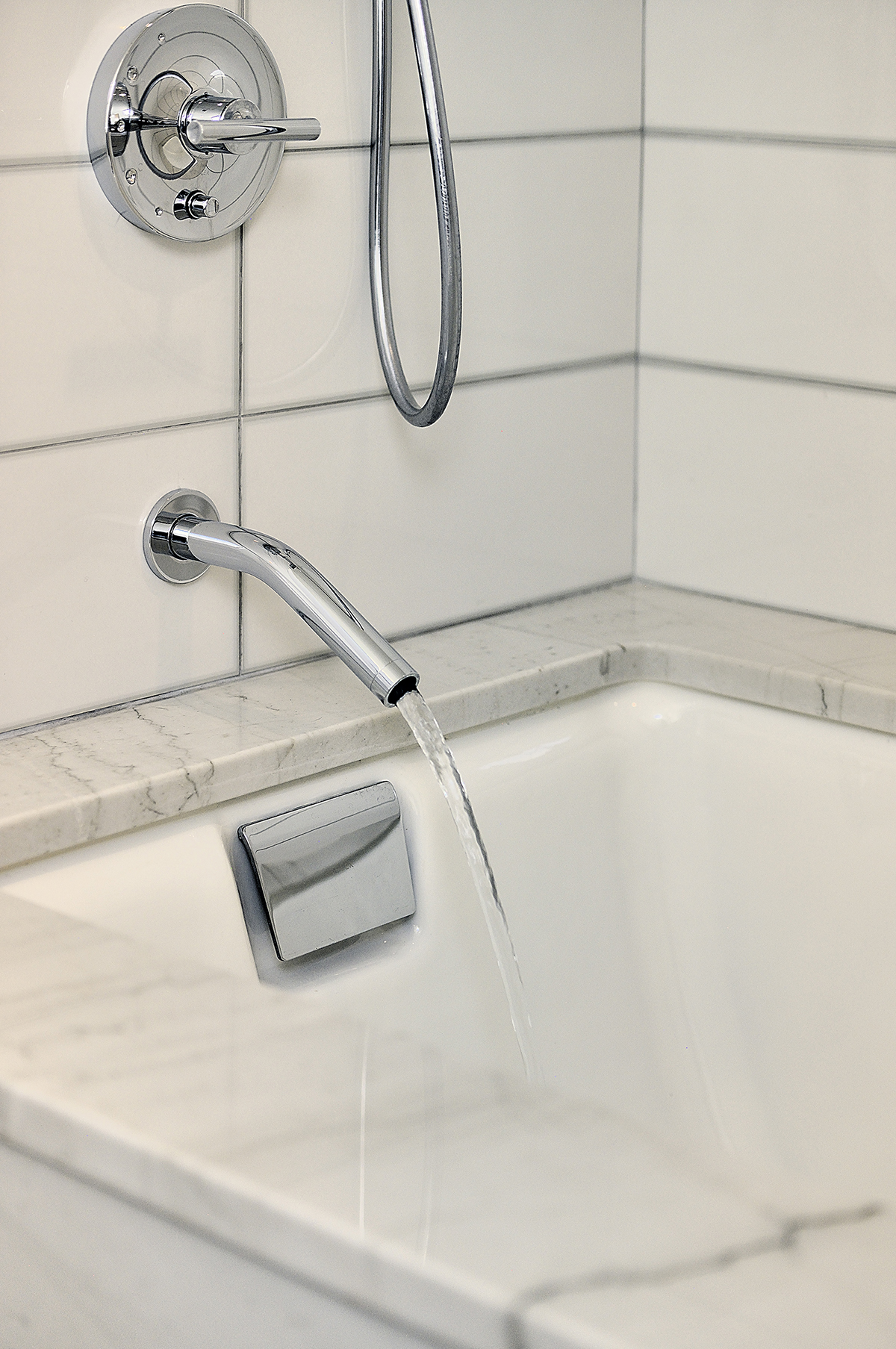 A bathtub with a faucet and a shower head designed by an architect.