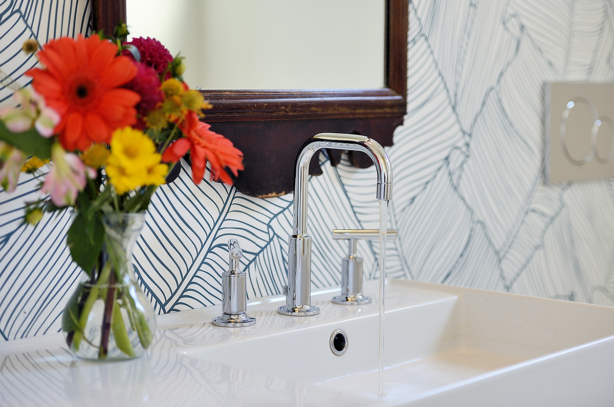 A beautiful Santa Fe-themed bathroom sink adorned with flowers and complemented by a mirror, expertly designed by a skilled home designer or contractor.