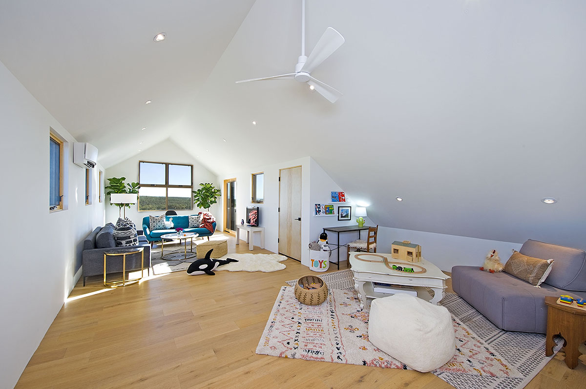 A living room with hardwood floors and a ceiling fan, designed by a home designer.