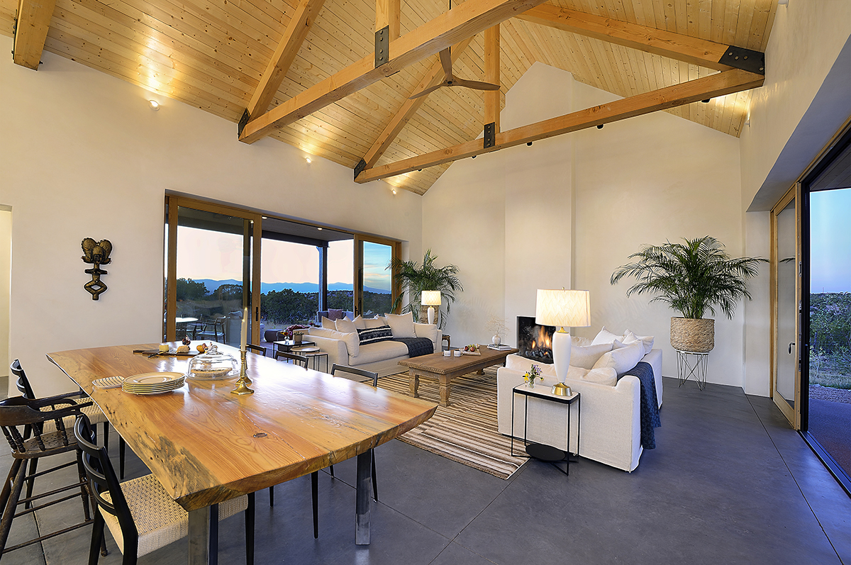 A spacious living room with a sleek dining table and comfortable chairs, expertly designed by a Santa Fe home designer.