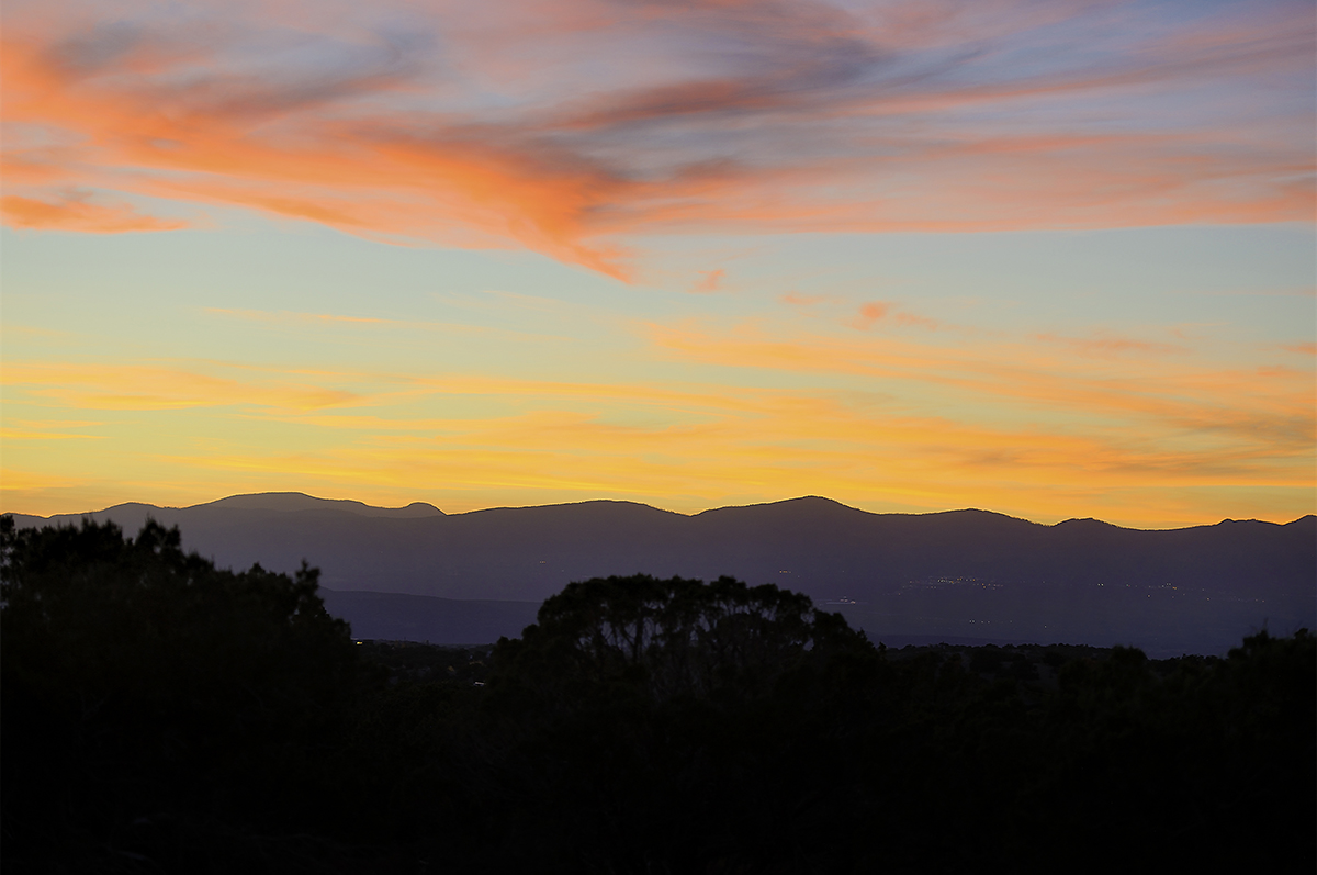 A contractor captures the beauty of a sunset over a mountain range while working on a construction project.