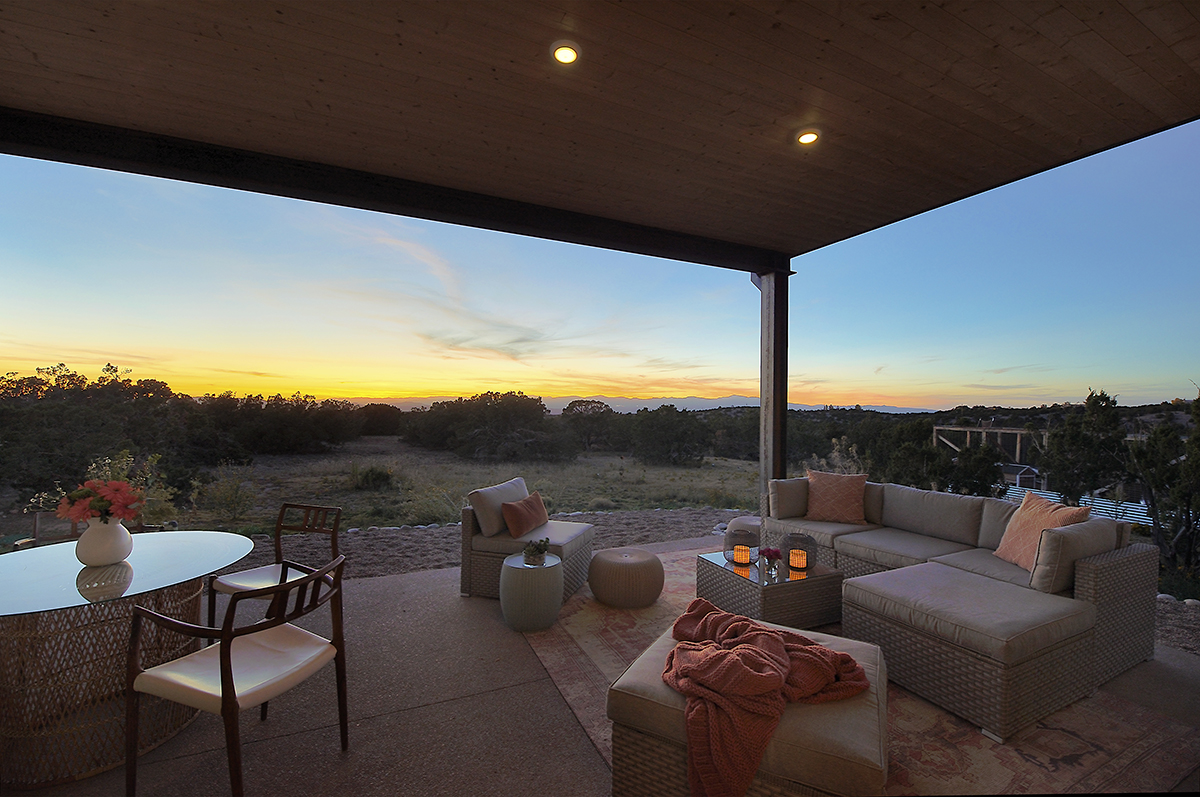 A patio designed and built by a home designer with a table and chairs.