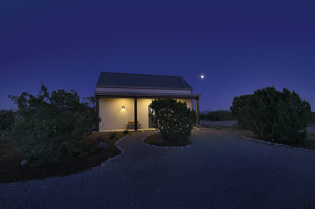 A Santa Fe-style home beautifully lit up at night.