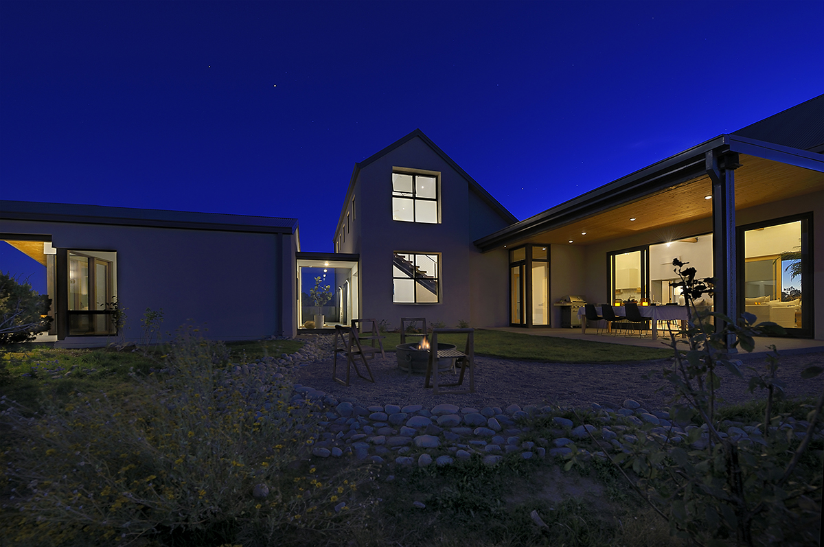          A house with a patio designed by an architect at night.