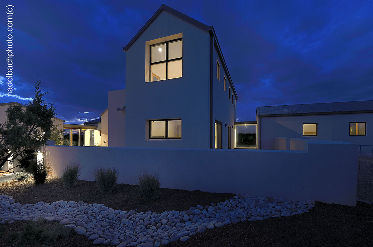 The architect-designed house in Santa Fe is beautifully lit up at night.
