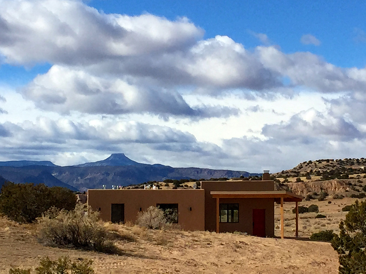 A Santa Fe-style home in the desert with mountains in the background, designed by an architect and built by a reputable home builder.
