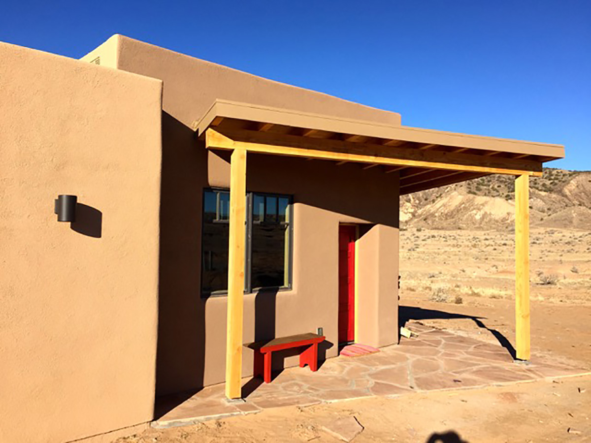A tan adobe house in Santa Fe, designed by a home designer.