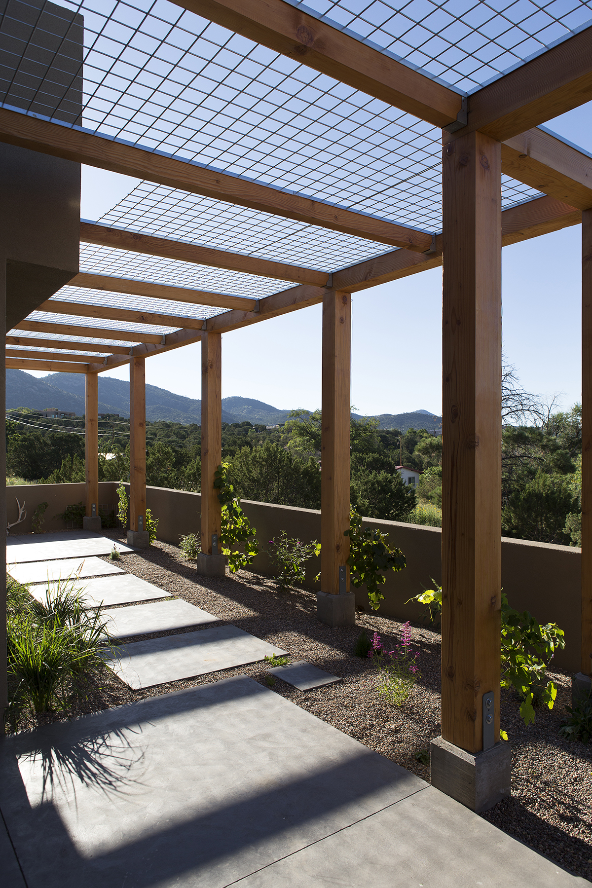 A wooden deck with a pergola designed and built by an architect.