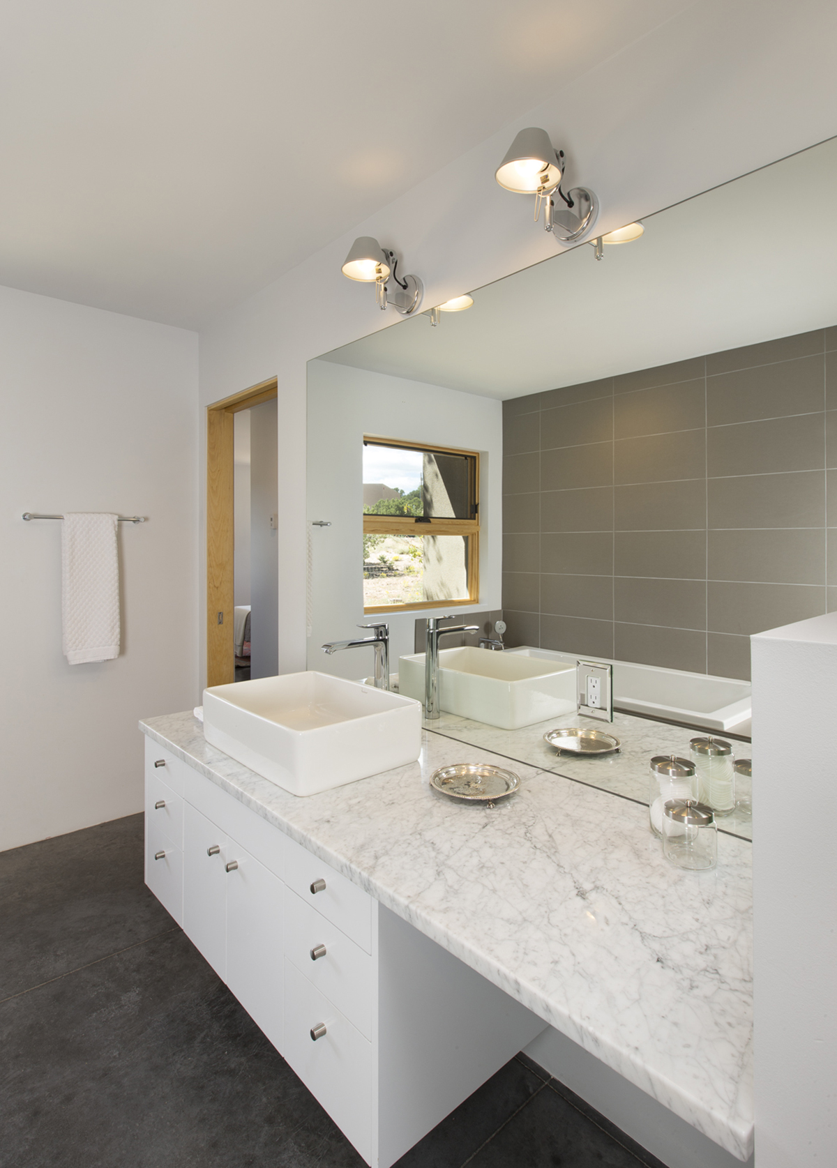 A Santa Fe style bathroom designed by an architect with two sinks and a mirror.