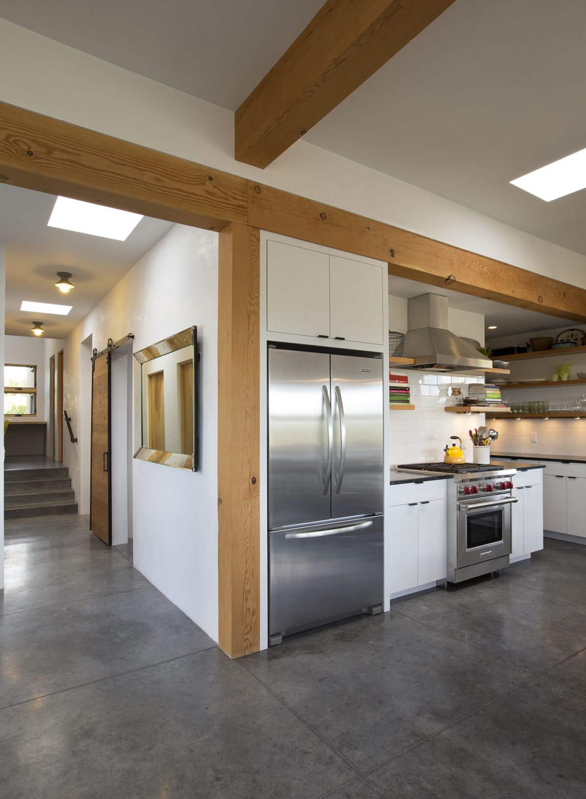 A kitchen with a stainless steel refrigerator designed by a home designer or home builder.