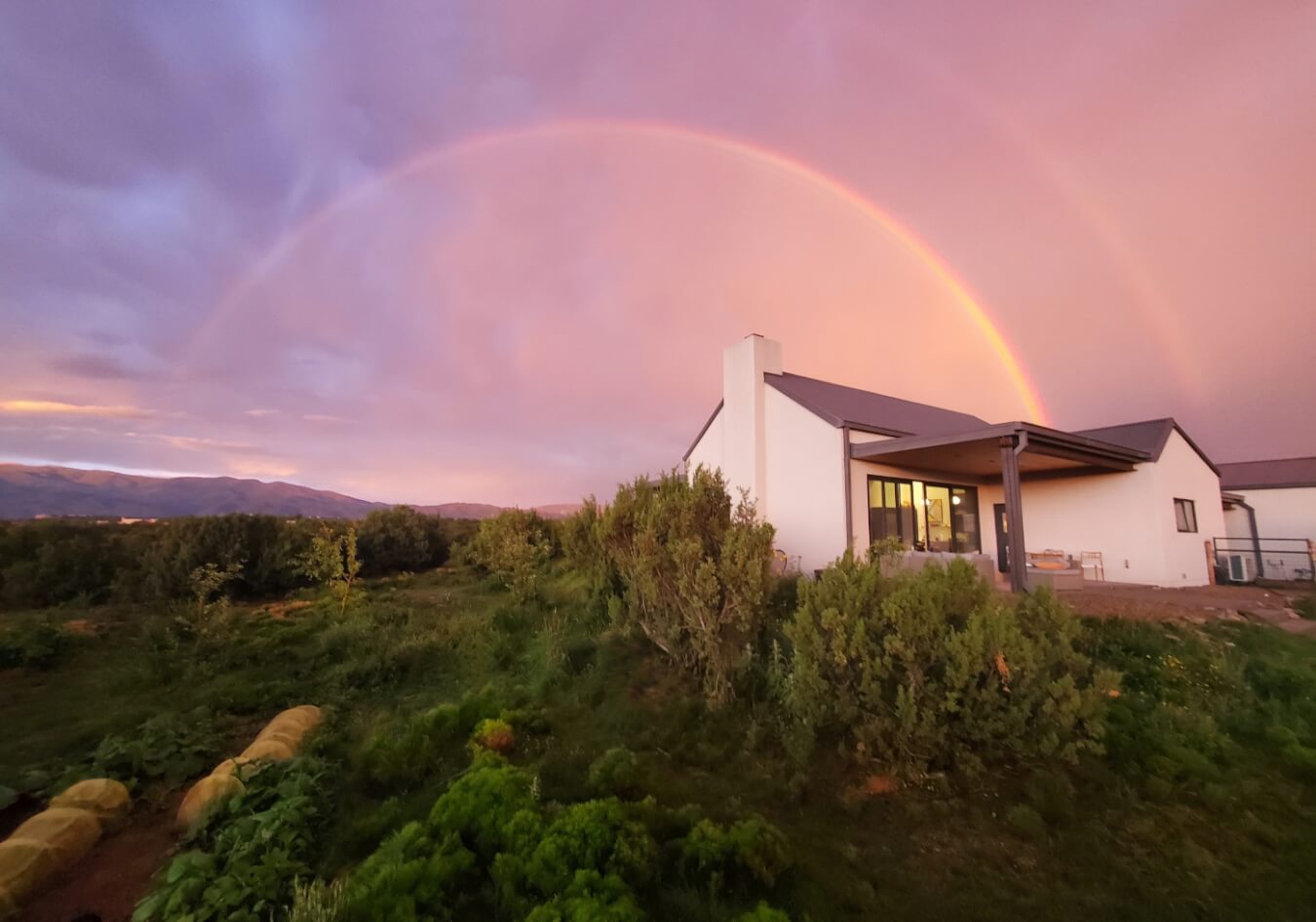A rainbow is seen over a house in the middle of a field in Santa Fe.