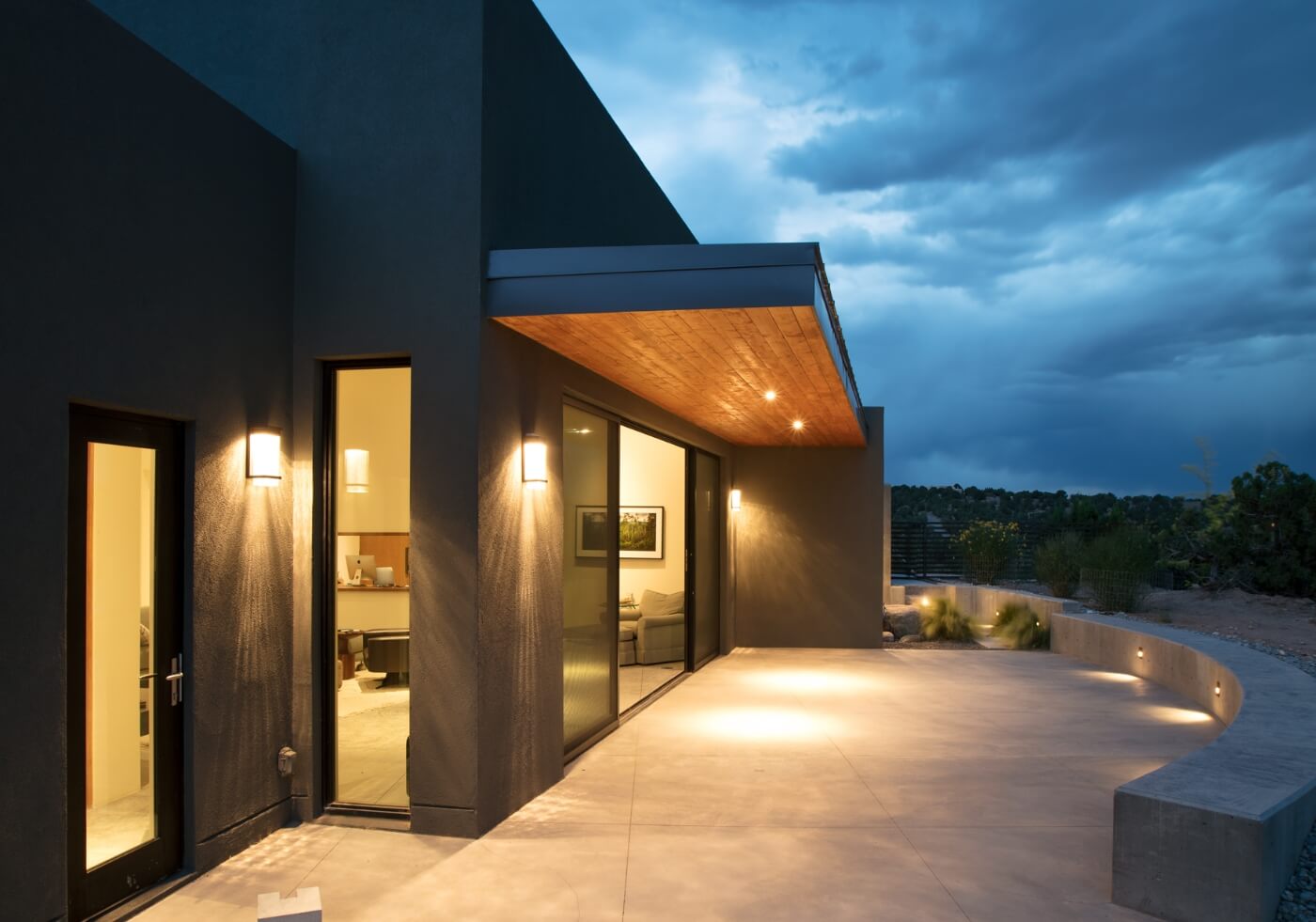 A Santa Fe style home is lit up at night.