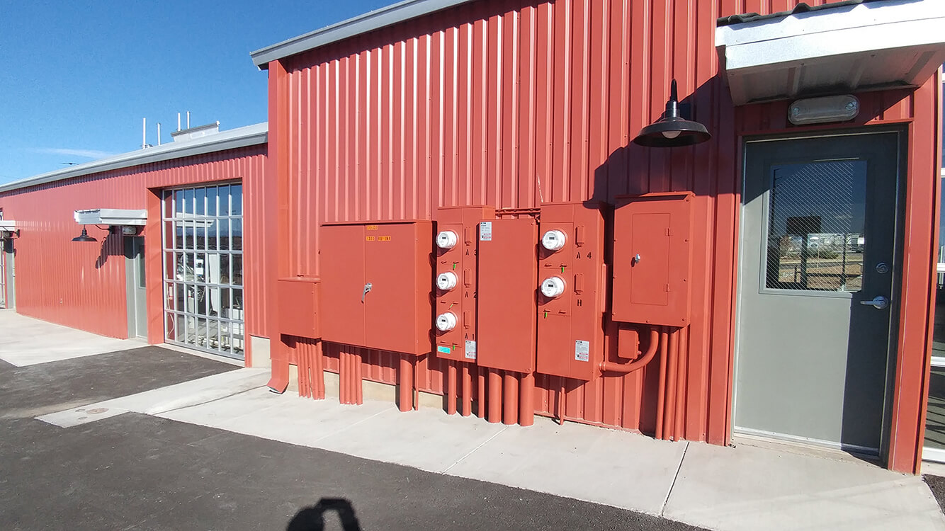 A red metal building with a red door designed by a home builder.