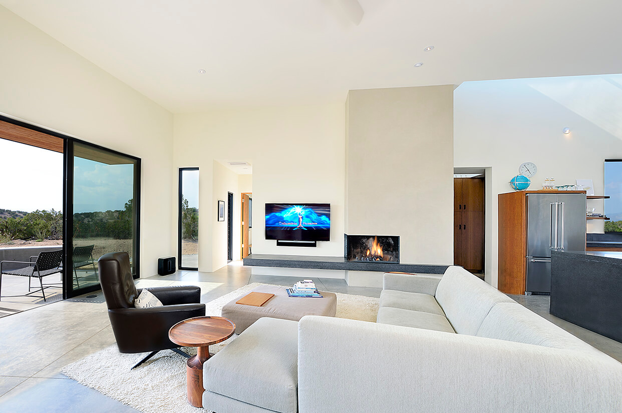 A Santa Fe style living room with a fireplace and sliding glass doors.