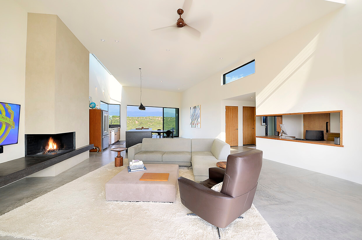 A Santa Fe-inspired living room with a fireplace and TV, designed by an architect.