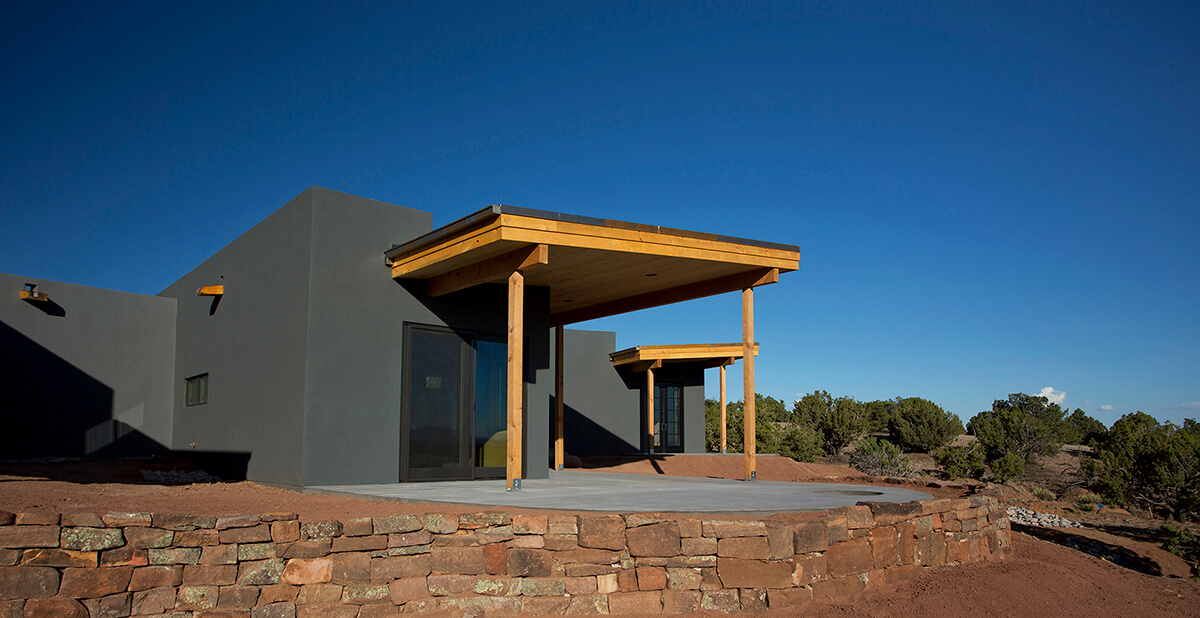 A modern house designed by an architect is sitting on top of a rocky hill contracted in Santa Fe.