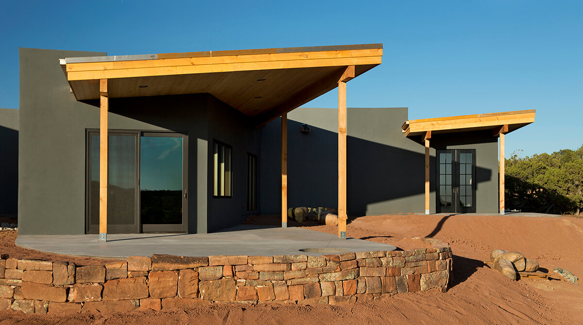 A Santa Fe style house is sitting on top of a sand hill.