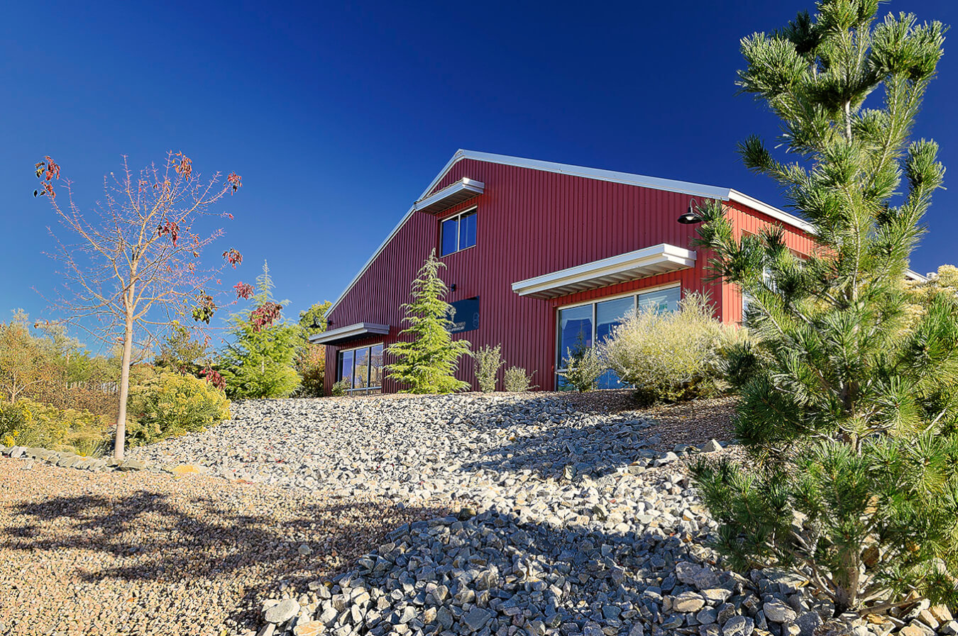 A red house, designed by Santa Fe, is sitting on top of a hill.