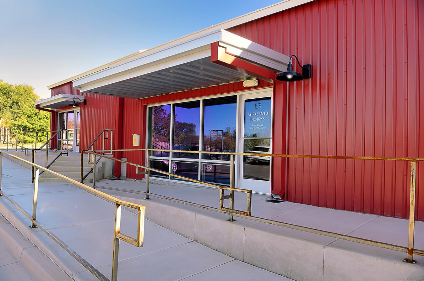 The Santa Fe-inspired entrance to a red building with metal railings, crafted by a skilled architect.