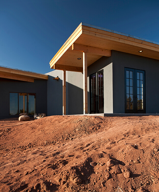 A architecturally designed house in the desert with a blue sky.