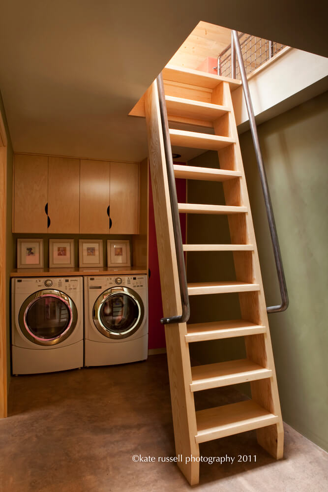 A Santa Fe-style laundry room with a ladder leading to a washer and dryer.