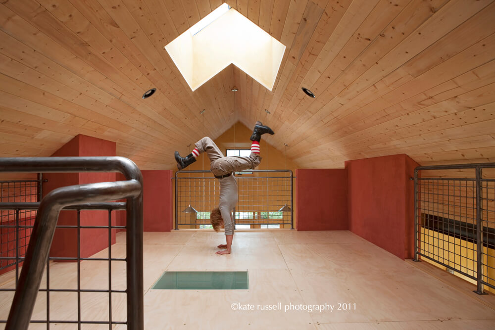 A man doing a handstand in a Santa Fe-inspired room.