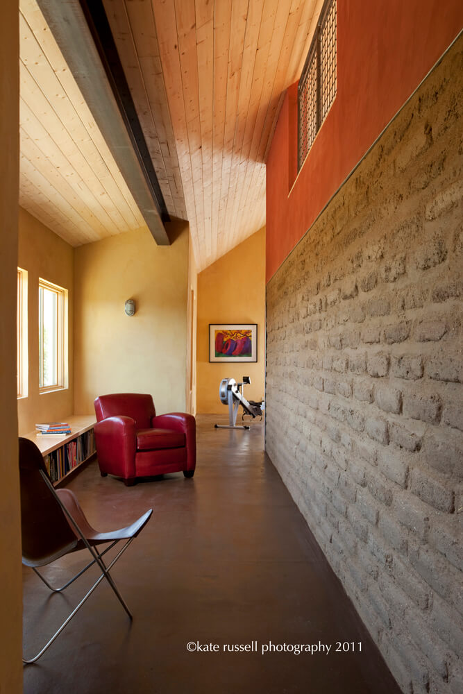 A room with a red chair and a brick wall, designed by an architect.