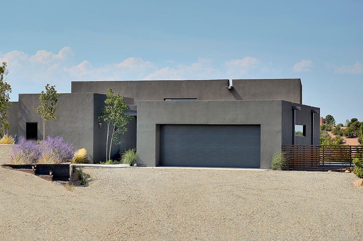 A modern home designed by a home designer with a driveway and a garage, located in Santa Fe.