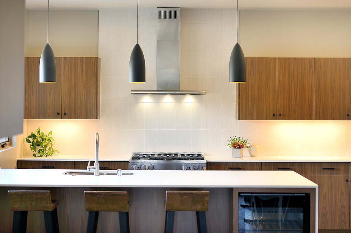 A modern kitchen designed by an architect with wooden cabinets and counter tops.