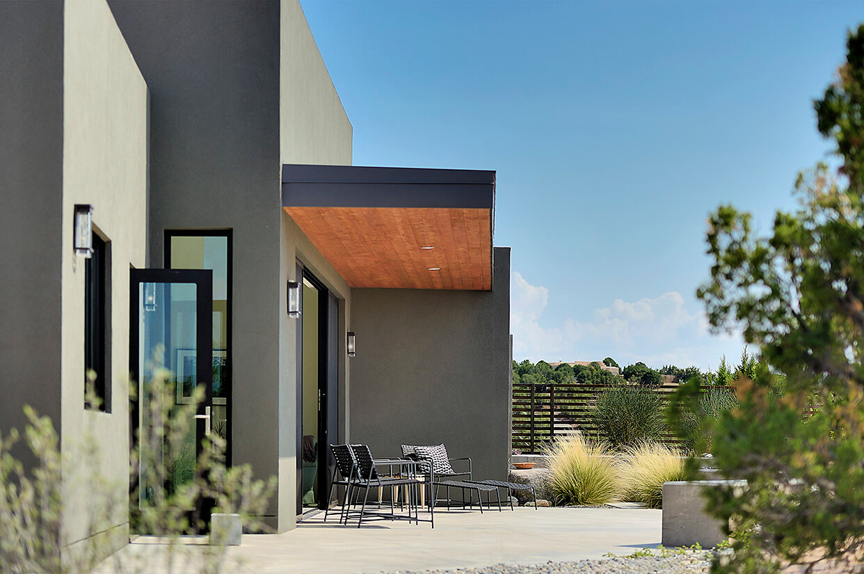 A Santa Fe-inspired home with a patio and chairs.