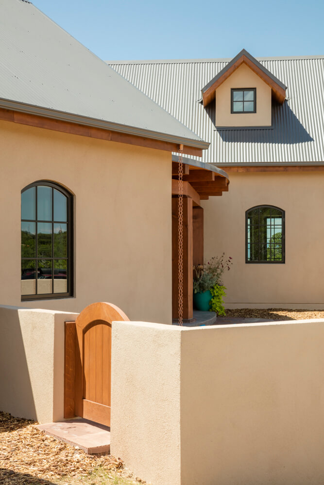 A Santa Fe adobe home with a wooden door, meticulously crafted by a talented home builder and architect.