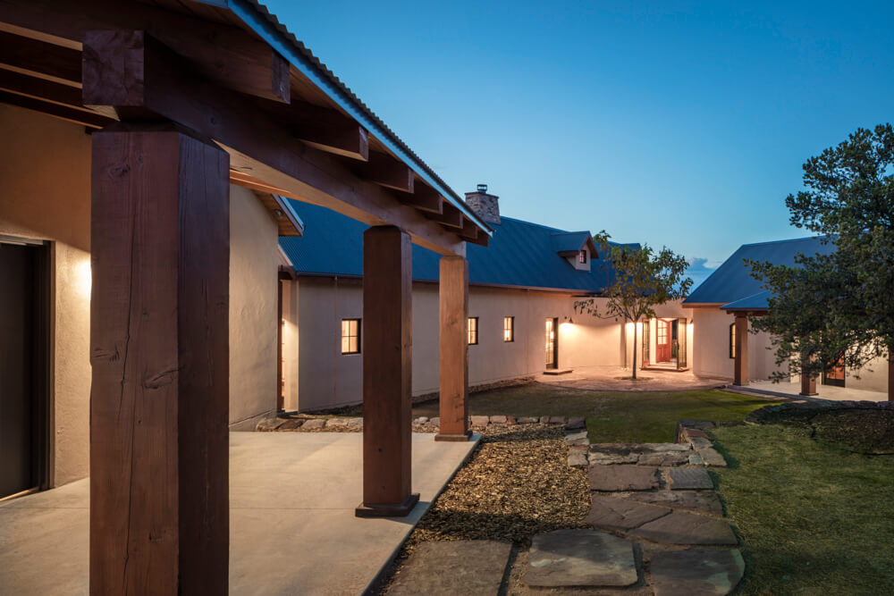 A architecturally designed house with a stone walkway and wooden columns.