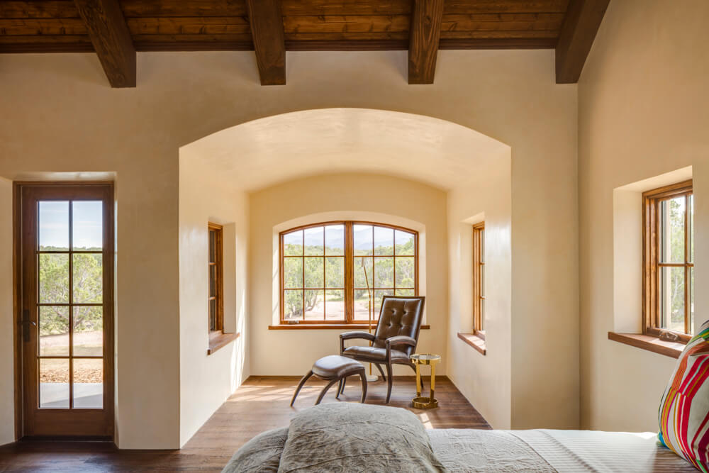 A Santa Fe-inspired bedroom with arched ceilings and wooden floors.