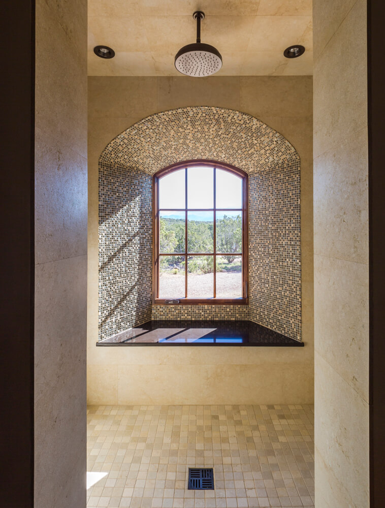 A bathroom with a window and tiled floor, designed by an architect.