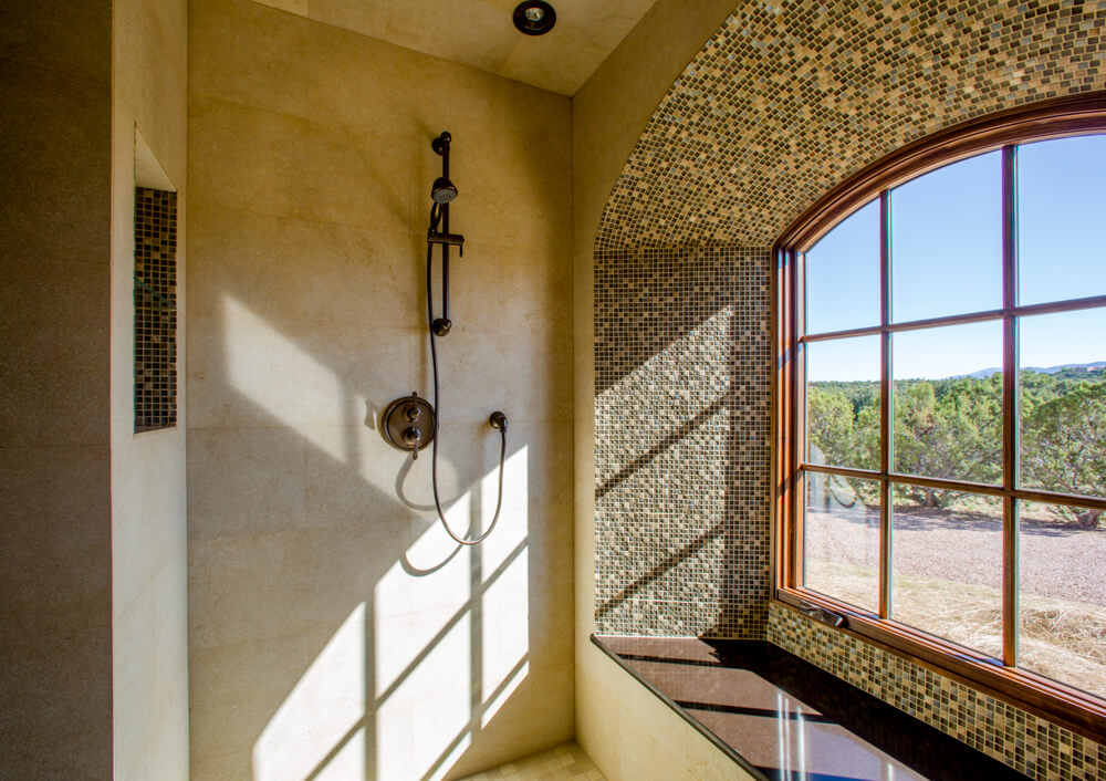 A shower with an arched window, designed by an architect.