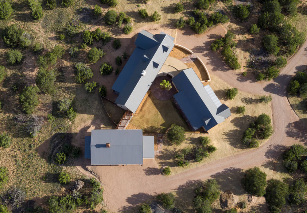 A Santa Fe inspired home designer showcases an aerial view of a house nestled in the desert.