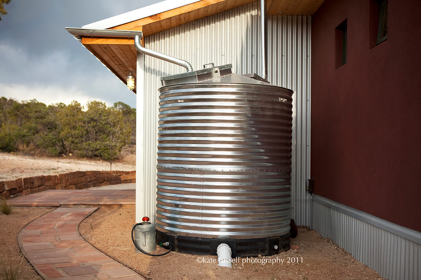 A metal water tank sits outside of a Santa Fe house.