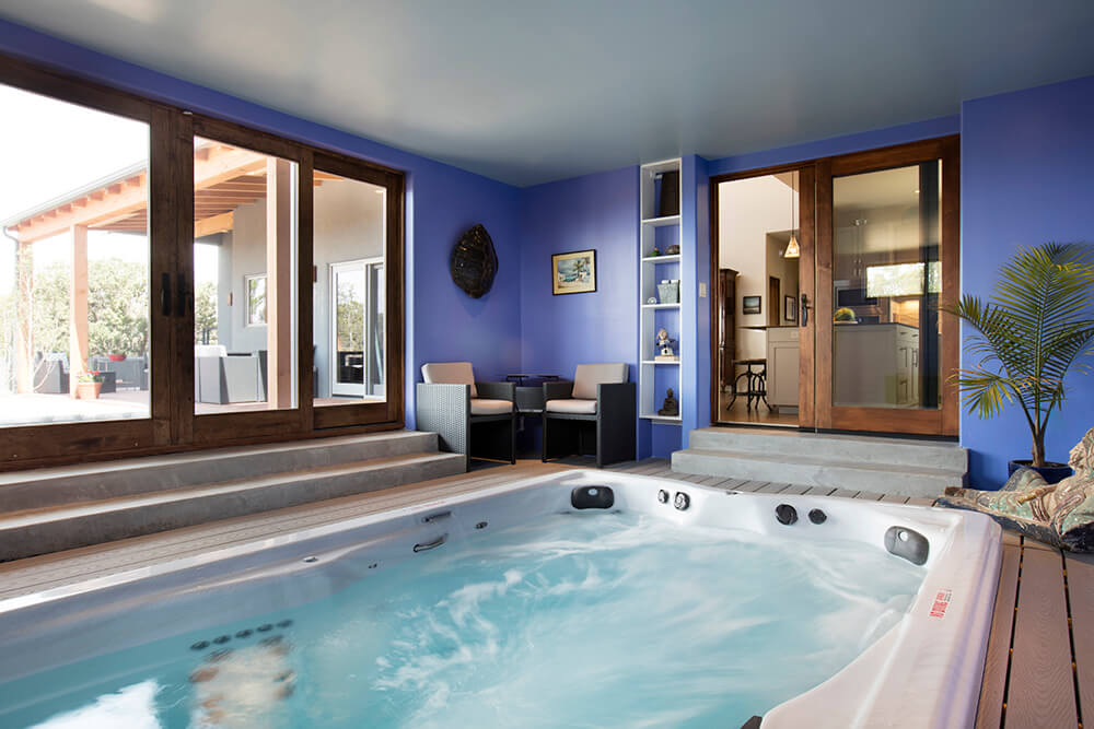 A hot tub in a room with blue walls designed by a home designer.