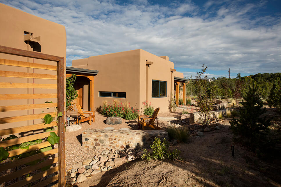 A beautiful adobe home with a wooden fence built by a skilled contractor.