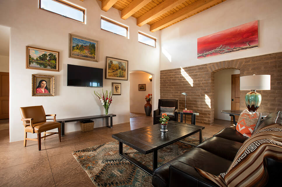A living room designed by a home designer in Santa Fe, featuring couches and a TV.