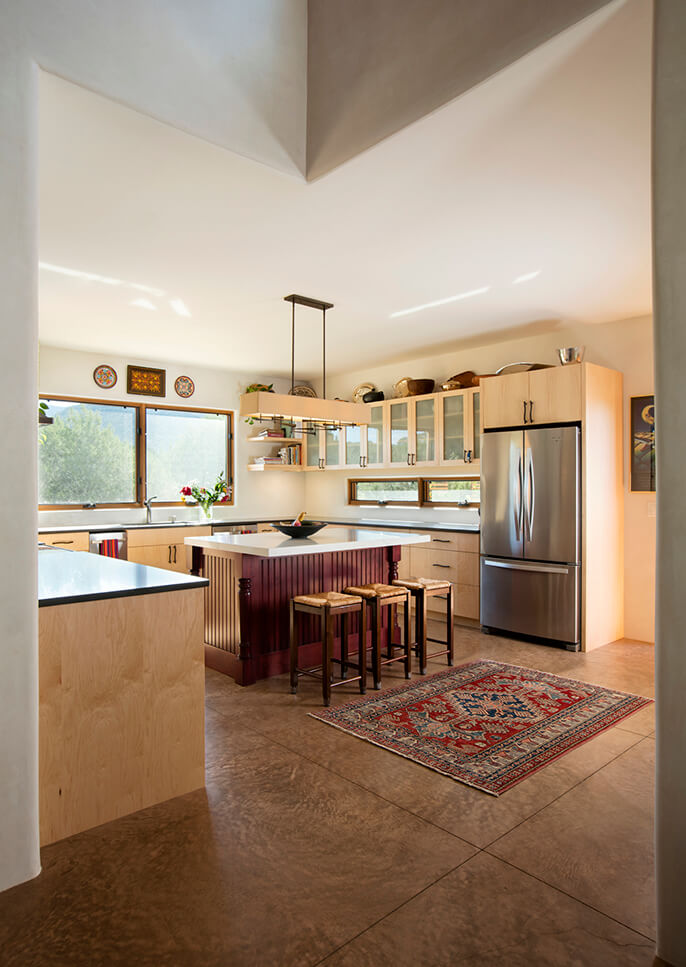 A kitchen designed by a home designer with a wooden floor and a rug.