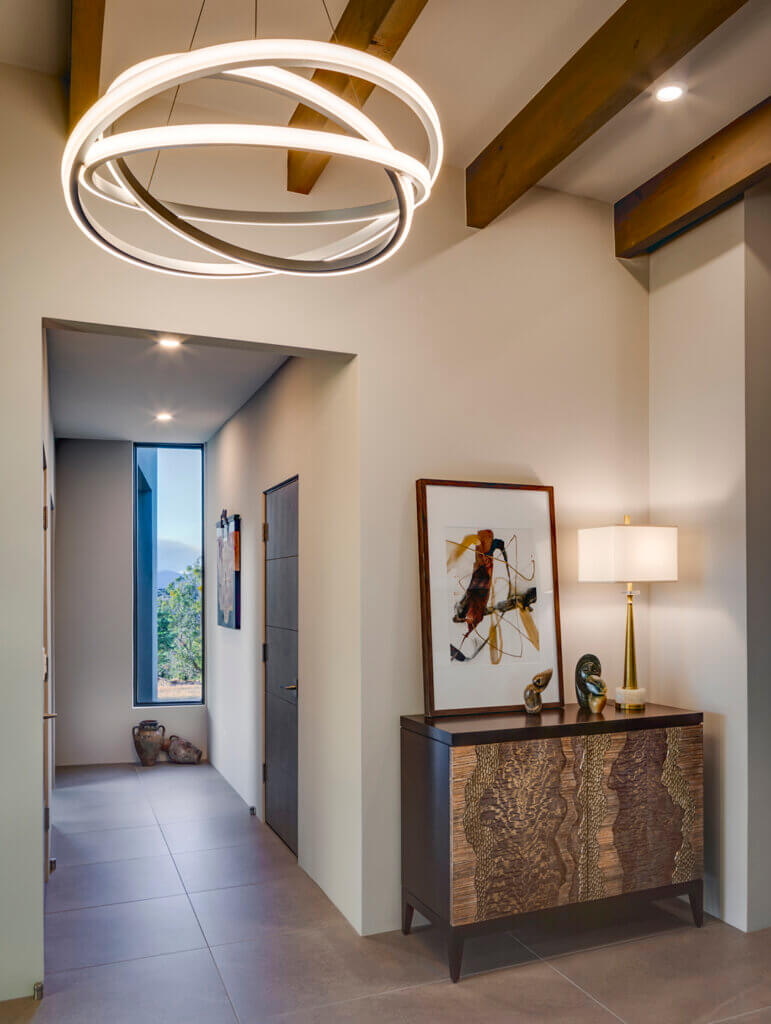 A modern hallway with a circular light fixture designed by an architect.