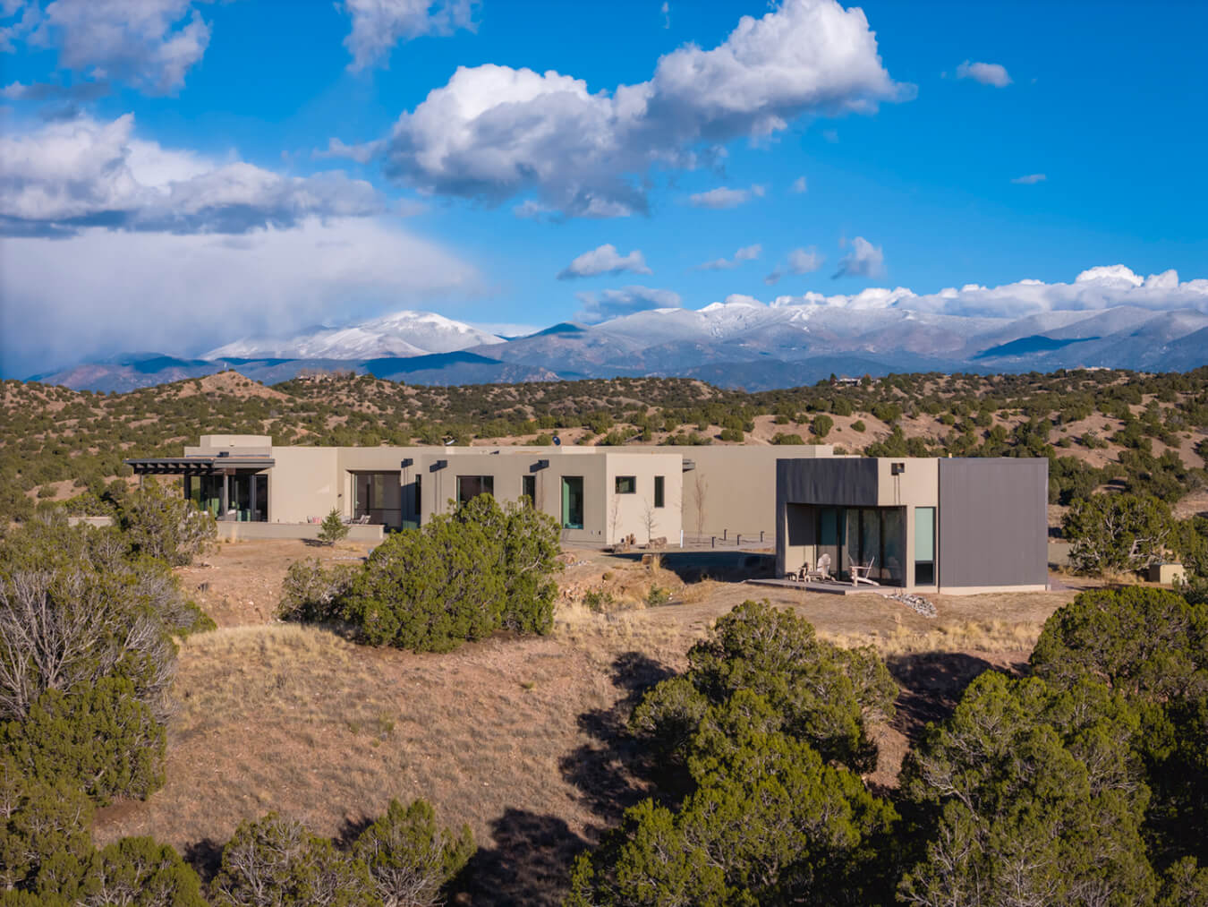 A Santa Fe-style home in the desert with mountains in the background, built by a skilled home builder.